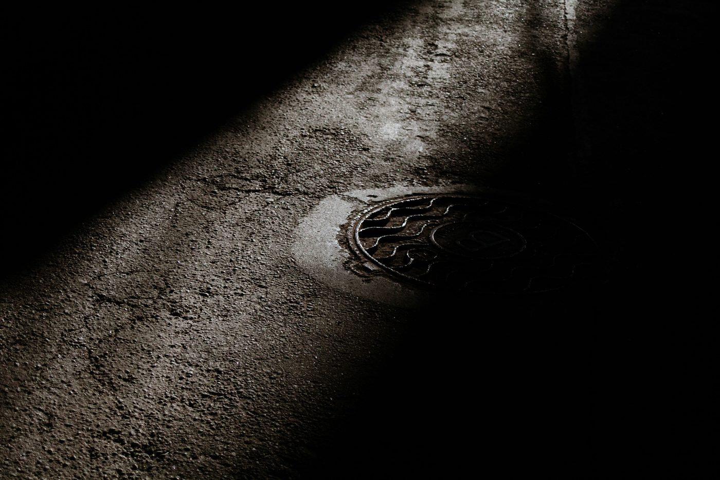 Drain cover in a dark road at night