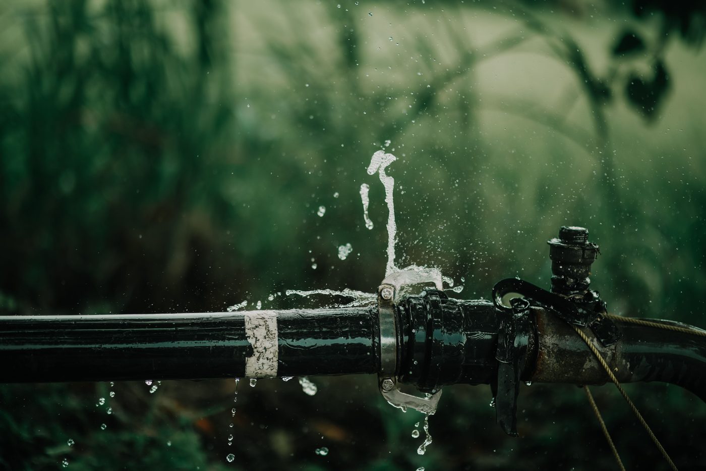 Water spraying from a split joint on a black water pipe